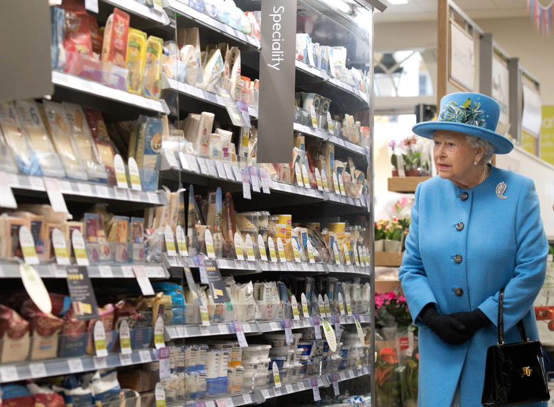 Queen Elizabeth II looks at products on the shelves at a Waitrose supermarket during a visit to the town of Poundbury on October 27, 2016 in Poundbury, Dorset. Photo via Getty Images.
